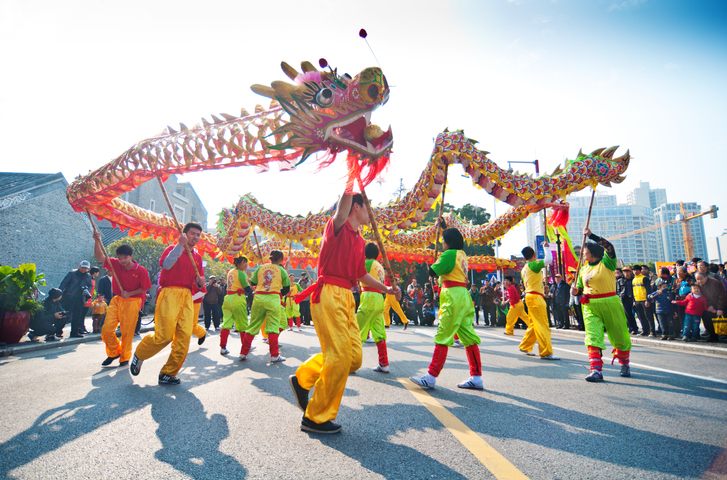 People doing a dragon dance in public.