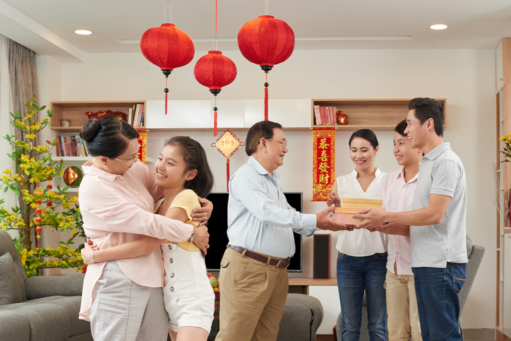 Asian family happily wishing each other a Happy Chinese New Year.